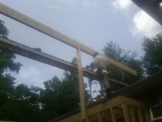 Carpenter setting a ridge beam over a new addition frame — Ice Dam Removal by Roofing Brothers in Eagleville