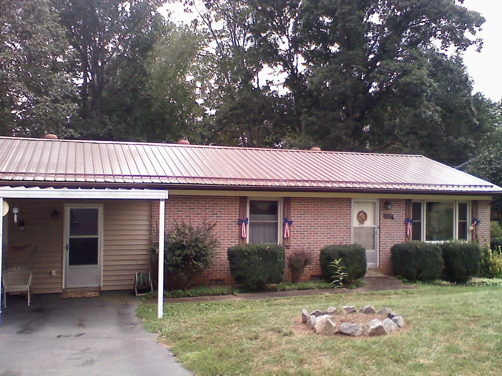 Bronze metal roof and carport on a brick ranch home — Roof Repair work by our crew in Eagleville